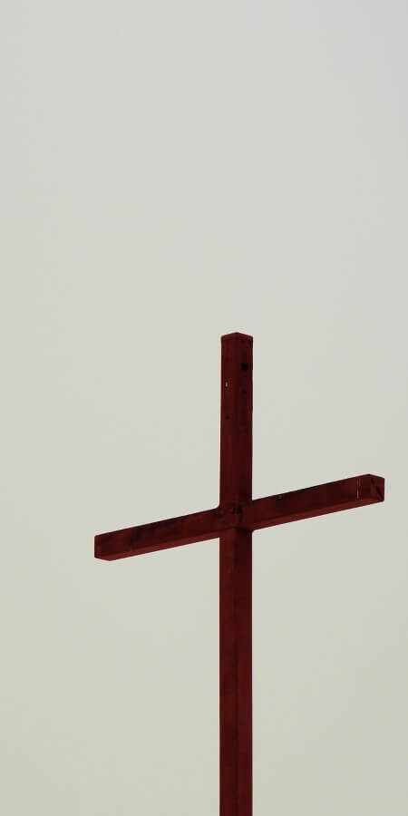 A tall cross in front of a dark sky background
